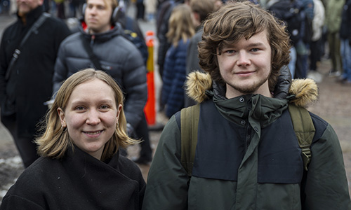 Två studenter framför en lång kö i snöglopp.