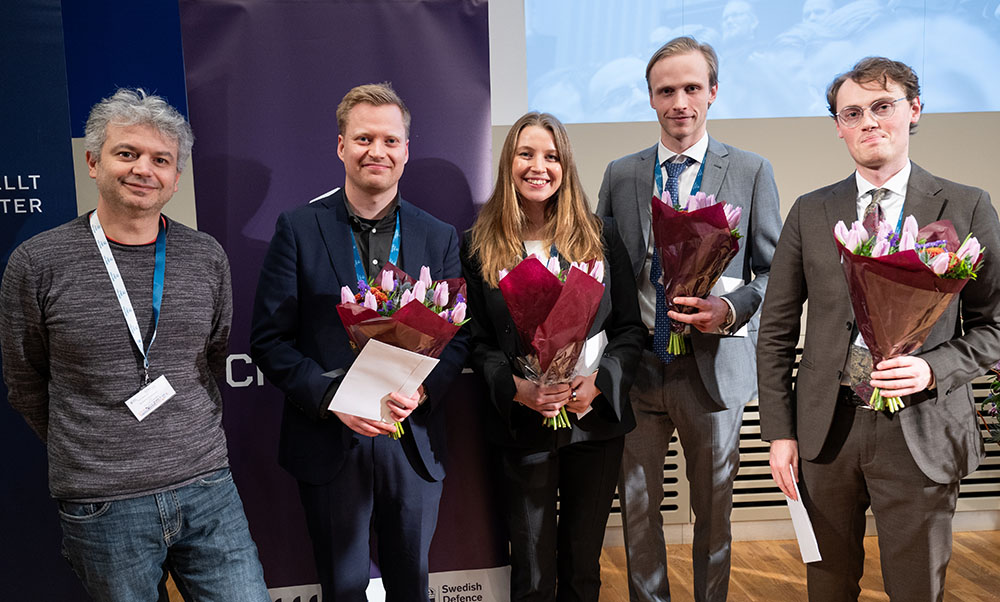 Five people with bouquets of flowers standing next to each other looking at the camera.